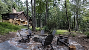 A cabin with a stone fire pit and Adirondack chairs. - BEAR'S DEN  - Spacious mountain home on river game room & fire pit in Burlingame (Sapphire)