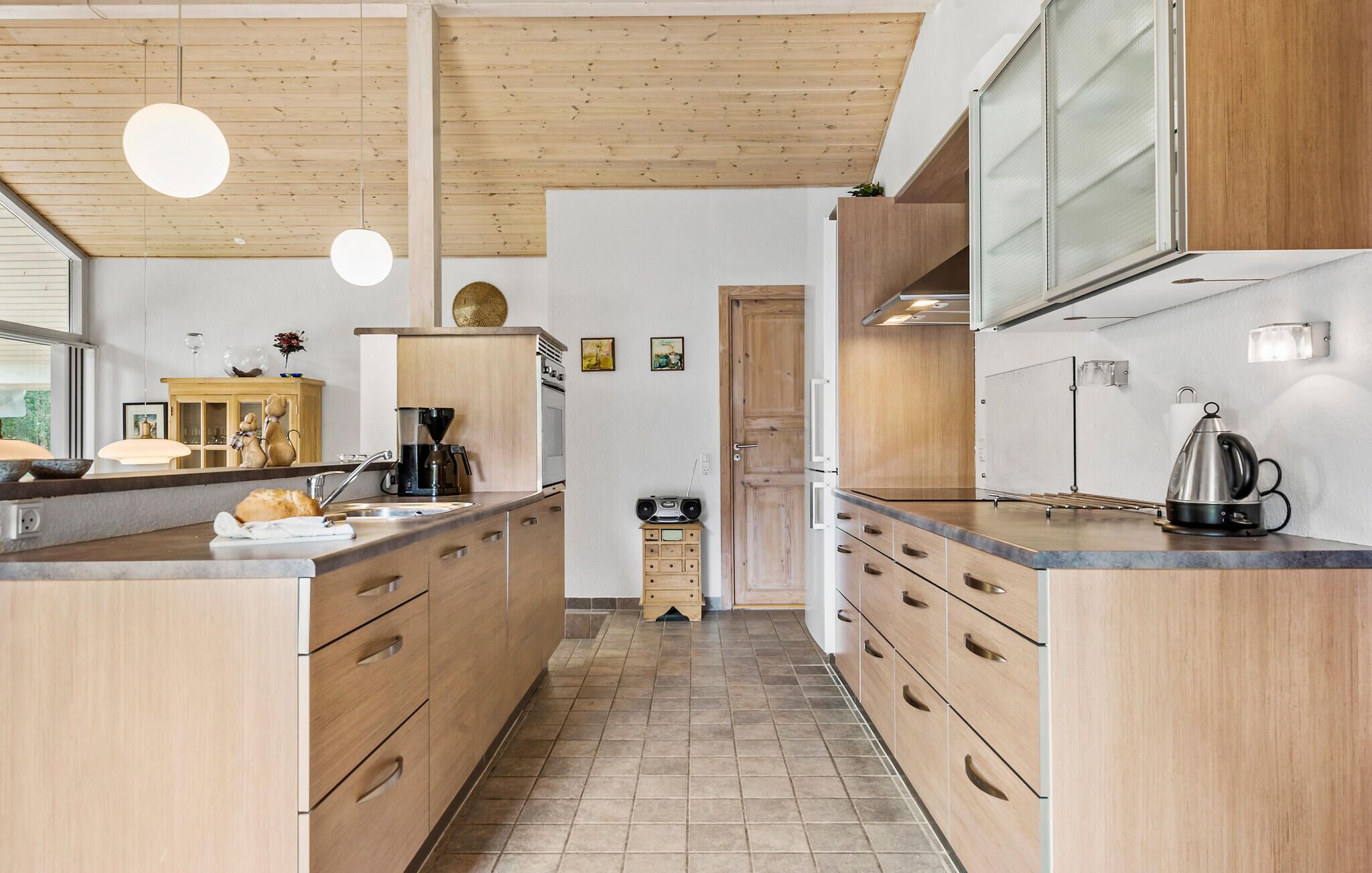 Una cocina moderna con armarios de madera, una isla central y piso de baldosas.