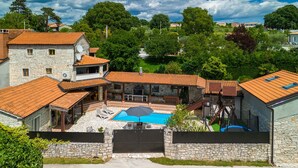 A stone building with a swimming pool, outdoor seating, and a stone wall. - Villa Antoli (Istria - Jakovici) (Jakovici)