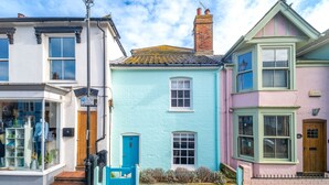 A row of colorful houses with distinct architectural styles, including a shop on the left.