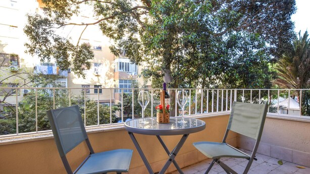 A balcony with two chairs, a table, and a bottle of wine. - 3 bedroom amazing apartment in Palermo (Palermo)