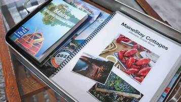 A brochure titled "MaineStay Cottages" with images of cottages, a lighthouse, and a scenic landscape.