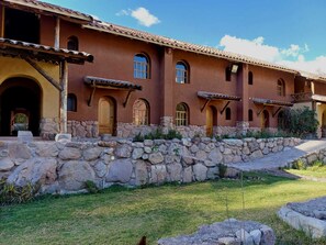 Un edificio tradizionale con pareti in pietra e portali ad arco, con una scala in pietra che conduce a un'area coperta.