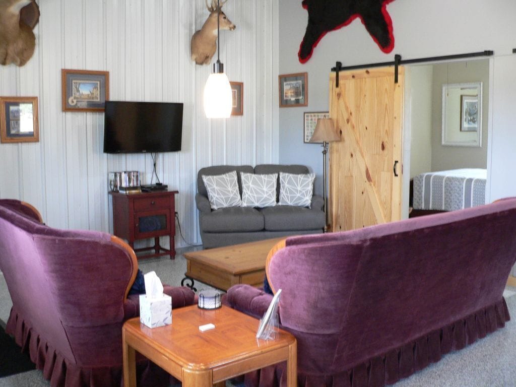 A living room with a sofa, a coffee table, a television, and a fireplace.