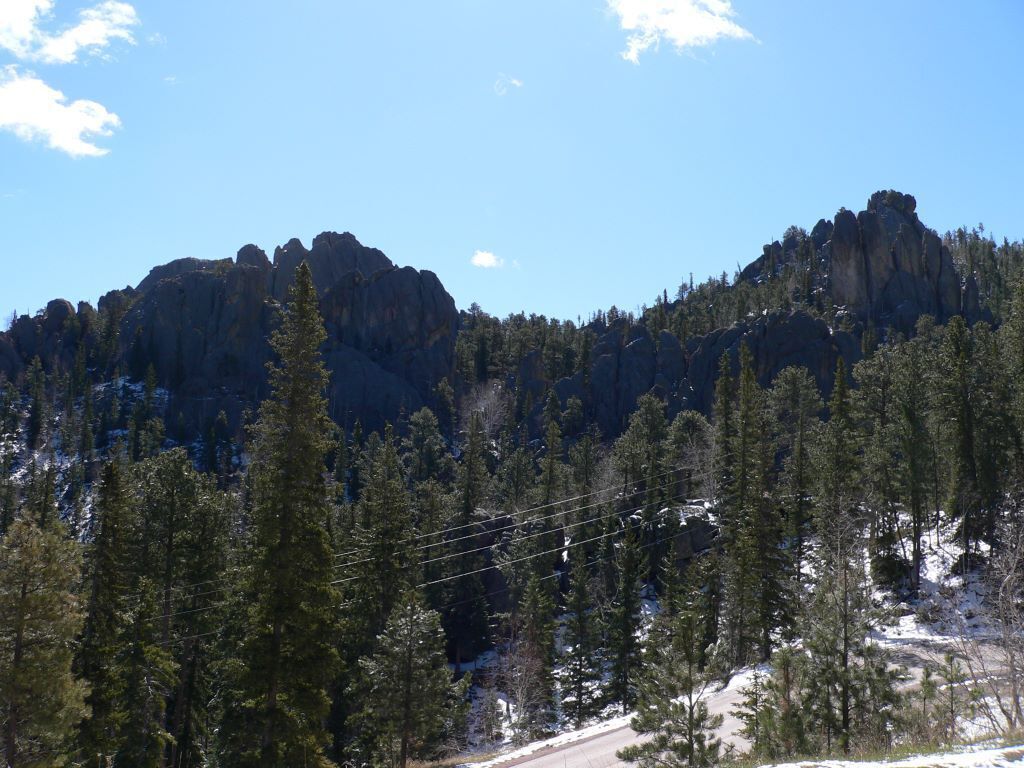 A mountainous landscape with dense forests and a clear sky.