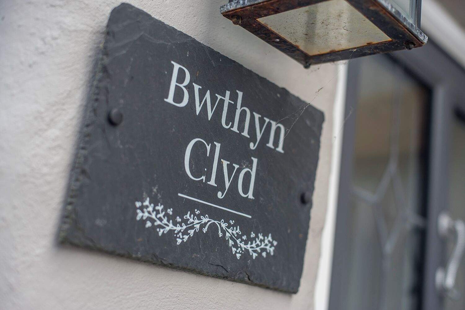 A slate sign with the name 'Bwithyn Clyde' mounted on a wall.