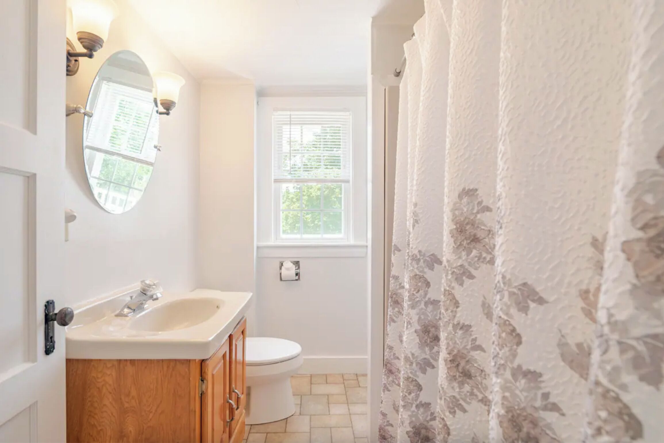 A bathroom with a sink, mirror, and toilet.