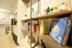 A hotel reception area with shelves displaying various items including a Game Block game, a KUMAMATSU Classic game, and other products. - Namyangju NO.25 Hotel Bukhan River (Namyangju)