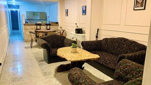 A living room with patterned sofas, a coffee table, and a dining area with chairs and a table. - Encantadora Casa en el Corazón de Guatapé, Perfecta Para Familias y Grupos! (Guatape)