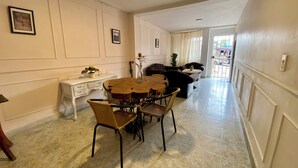 A dining area with a round wooden table and chairs, a white console table with a plant, and a sofa in the background. - Encantadora Casa en el Corazón de Guatapé, Perfecta Para Familias y Grupos! (Guatape)