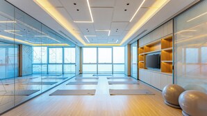 Ein modernes Fitnessstudio mit Übungsmatten, einem Fernseher und Trainingsbällen.