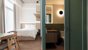 Una habitación de hotel con cama, escritorio y baño.