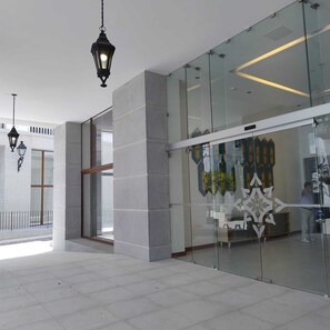A modern interior with glass walls, a patterned wall decoration, and hanging lanterns. - Cayalá Lofts (Guatemala City)