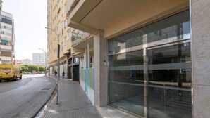 A modern building with large glass windows and a clean, tiled sidewalk. - PLAYAMAR - Nice flat near the sea in Cadiz and Free WiFi (Cádiz)