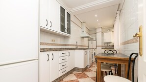 A kitchen with white cabinets, a granite countertop, and a checkered floor. - PLAYAMAR - Nice flat near the sea in Cadiz and Free WiFi (Cádiz)