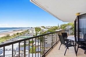 Un balcón con vista a la playa y al paisaje urbano.
