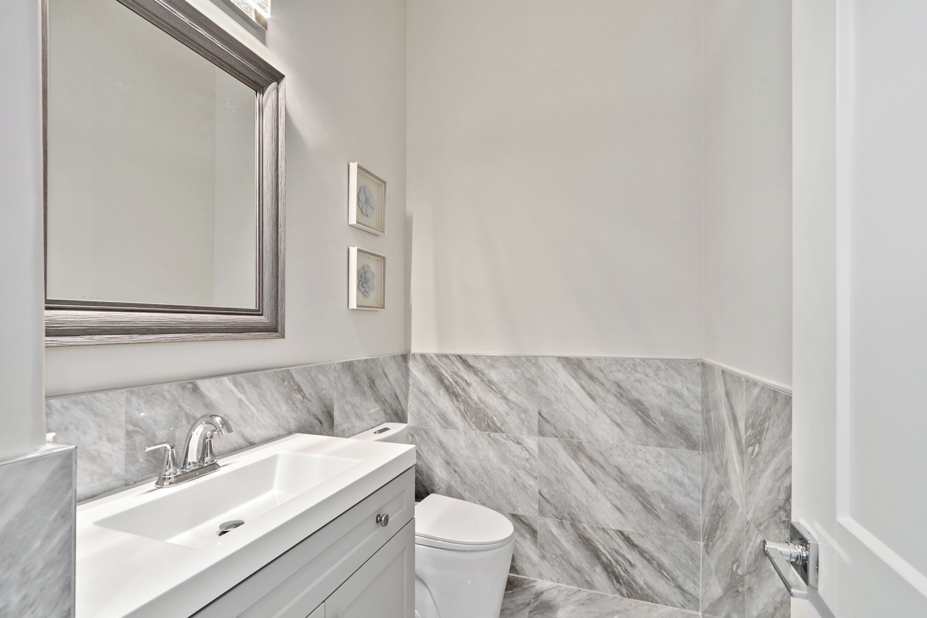 Une salle de bain avec un lavabo blanc, un miroir et des toilettes.
