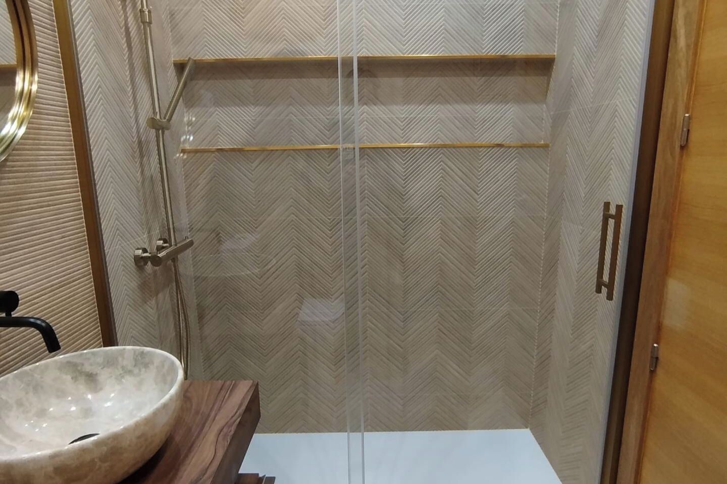 A bathroom with a shower, a sink, and a mirror.