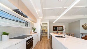 Una cocina moderna con armarios blancos, una isla central y vistas al área de comedor.