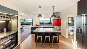 A modern kitchen with a central island, stainless steel appliances, and a view to the outside.
