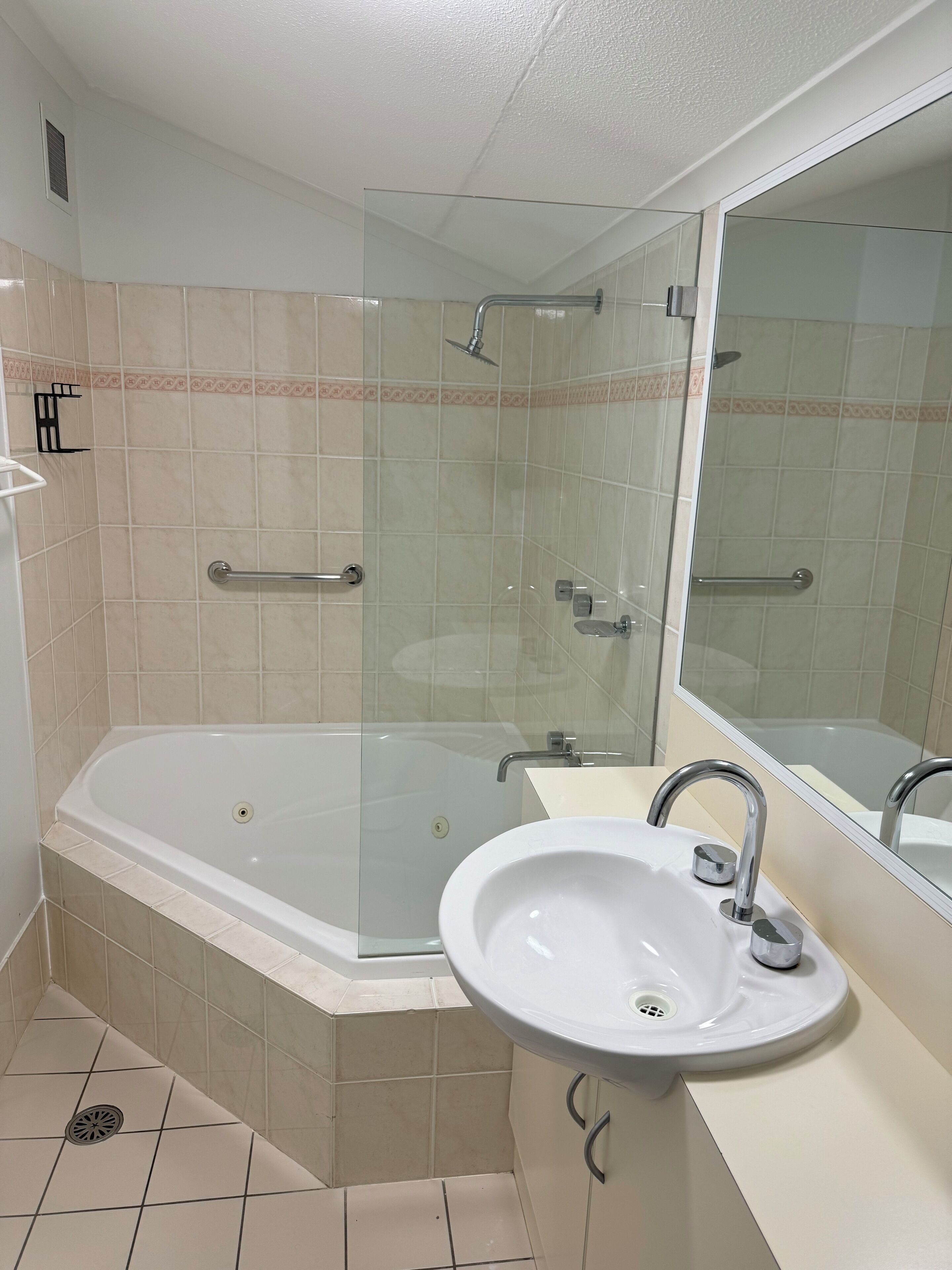A modern bathroom with a glass-enclosed shower, a freestanding bathtub, and a sink with a mirror.