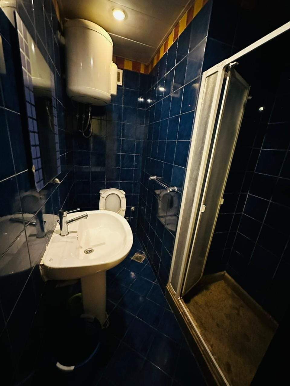 A bathroom with a white sink, a toilet, and a shower area.