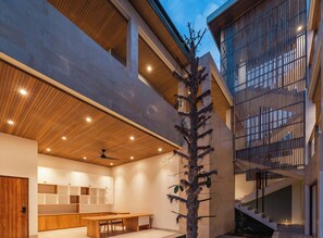 A modern interior with a wooden ceiling, a staircase, and a dining area. - Villa Avocagolf Uluwatu by Nakula (Pecatu)