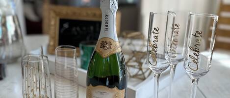 Een fles Korbel champagne en drie glazen op een houten tafel.