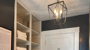 A bathroom with a white door, a white sink, a mirror, and a hanging light fixture. - Charming Pet-Friendly Stay: Walk BC, 7.5 mi to JMU, walk to Dining, Parks & more (Bridgewater)