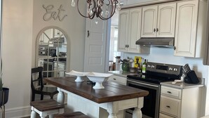 A kitchen with a central island, white cabinetry, and a chandelier. - Charming Pet-Friendly Stay: Walk BC, 7.5 mi to JMU, walk to Dining, Parks & more (Bridgewater)