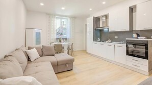 Ein modernes Apartment mit Wohnzimmer, Küchenzeile und Essbereich.