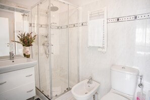 A bathroom with a glass-enclosed shower, a sink, a bidet, and a toilet. - Royale Sejour - Apartment for 4, Menton, France (Menton)