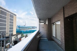 Un balcón con vistas a un crucero y un edificio al otro lado del agua.