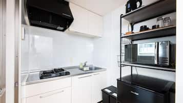 A compact kitchen with a gas stove, a microwave, and a built-in oven.