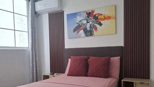 A bedroom with a bed, a ceiling fan, an air conditioning unit, a painting, and a window with curtains. - Apartamento a Solo 15 Minutos del Aeropuerto con Piscina (Panamá)