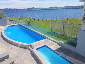 A swimming pool with a view of a lake and hills.