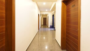 Un pasillo con puertas de madera, piso pulido y el número 401 en una puerta.