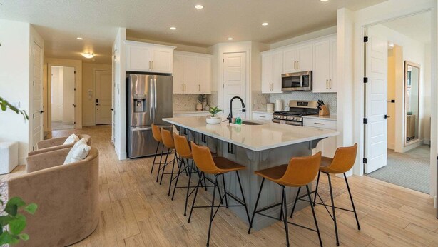 A modern kitchen with a central island, bar stools, and stainless steel appliances. - Red Rock Haven - NEW Private Pool, putting green, & more. Perfect family retreat (Washington)