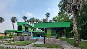 A modern house with a green exterior, a swimming pool, and a well-maintained garden. - Encanto Llanero Xkpdestinations (Villavicencio)