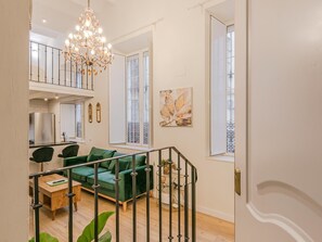 A modern living room with a green sofa, a wooden coffee table, and a chandelier. - Duplex Sevilla dreams (Sevilla)