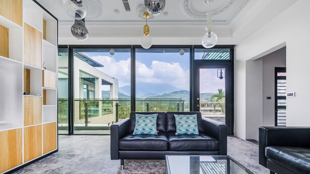 A modern living room with a black leather sofa, a glass coffee table, and a wooden bookshelf. - Han Yan Hill Hotel (Yuchi)