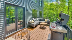 A deck with a sofa, a round table, and a grill. - Swanton Retreat w/ Game Room, Hot Tub & Trails! (Swanton)