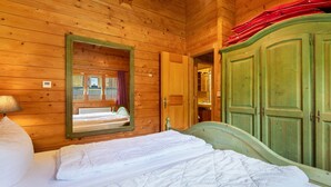 A wooden room with a bed, a mirror, and a green wardrobe. - Apartment 'Blockhaus Hedwig Zwei' with Shared Pool, Private Terrace and Wi-Fi (Stamsried)