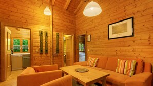 A wooden interior with a sofa, chairs, a table, and a framed picture on the wall. - Apartment 'Blockhaus Hedwig Zwei' with Shared Pool, Private Terrace and Wi-Fi (Stamsried)