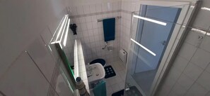 Un baño con inodoro, lavamanos y ducha.