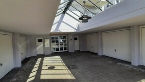 Un intérieur spacieux doté d’une verrière, de plusieurs portes et d’un sol carrelé.