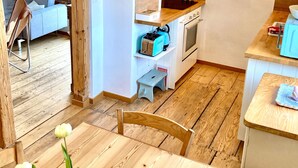 A cozy kitchen with wooden cabinets, a built-in oven, and a small countertop. - Holiday Home 'Ferienhaus bei Juste' with Private Terrace, Shared Garden and Wi-Fi (Schotten)
