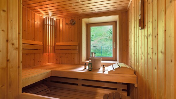 Una sauna con panche di legno, una finestra e un orologio a parete.