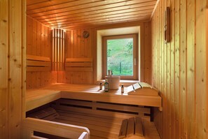 Una sauna con bancos de madera, una ventana y un reloj en la pared.