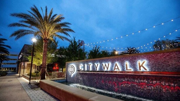 A nighttime view of CITYWALK with illuminated signage, palm trees, and string lights. - Quiet 1-Story Townhome off I-75 by UF, Shands, VA, Celebration Pointe &Shopping! (Gainesville)